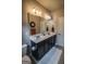 This spacious bathroom features double sinks with dark cabinets, tile floors and fluffy white rug at 6248 Sunshine Cove Ln, Buford, GA 30518