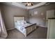 Neutral bedroom boasts a tray ceiling, ceiling fan, window and a cozy bed at 6248 Sunshine Cove Ln, Buford, GA 30518