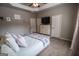Neutral bedroom boasts a tray ceiling, ceiling fan, window and a cozy bed at 6248 Sunshine Cove Ln, Buford, GA 30518