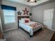 Cozy bedroom with a bed dressed in quilts and a window adorned with blue curtains and star decorations at 6248 Sunshine Cove Ln, Buford, GA 30518