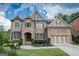 Stunning two-story home with stone and brick facade, manicured lawn, and a two-car garage at 6248 Sunshine Cove Ln, Buford, GA 30518