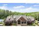 Stately home with a stone and shake facade, featuring a covered entry, landscaping, and mature trees at 6248 Sunshine Cove Ln, Buford, GA 30518