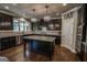 A gourmet kitchen with dark cabinets, granite countertops, and stainless steel appliances offers modern elegance at 6248 Sunshine Cove Ln, Buford, GA 30518