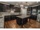 Well-lit kitchen features a central island, granite countertops, and stylish dark wood cabinetry and stainless appliances at 6248 Sunshine Cove Ln, Buford, GA 30518
