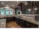 Spacious kitchen features granite countertops, gas range, tiled backsplash, and an abundance of dark wood cabinets at 6248 Sunshine Cove Ln, Buford, GA 30518