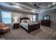 Spacious main bedroom boasts a tray ceiling, ceiling fan, window and two chairs at 6248 Sunshine Cove Ln, Buford, GA 30518