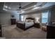 Spacious main bedroom boasts a tray ceiling, ceiling fan, window and two chairs at 6248 Sunshine Cove Ln, Buford, GA 30518