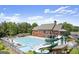 Community pool with slide, clubhouse, lounge chairs, and green space surrounded by trees at 6248 Sunshine Cove Ln, Buford, GA 30518