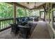 Relax on the cozy screened porch featuring comfortable seating, a ceiling fan, and scenic outdoor views at 6248 Sunshine Cove Ln, Buford, GA 30518