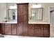 Bathroom featuring dual sinks, dark wood cabinetry, and a central storage tower with mirrors at 50 Star Spangled Ln, Peachtree City, GA 30269