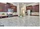 Close up of kitchen island featuring granite countertops, stainless steel appliances, a gas range and dark wood cabinetry at 50 Star Spangled Ln, Peachtree City, GA 30269
