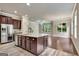 Open-concept kitchen featuring a large center island with granite countertops, stainless steel appliances and dark wood cabinets at 50 Star Spangled Ln, Peachtree City, GA 30269