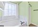 Modern bath with a soaking tub and decorative window in the main bathroom at 147 Calico Loop, Grantville, GA 30220