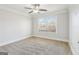 Bedroom with neutral carpet, ceiling fan, and white trim. Large window for natural light at 266 Hanover Dr, Villa Rica, GA 30180