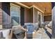 Relaxing front porch area with cozy seating, stone accents, and a wood-paneled ceiling at 266 Hanover Dr, Villa Rica, GA 30180