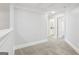 Hallway with neutral carpet and white trim, open doorway to bathroom at 266 Hanover Dr, Villa Rica, GA 30180