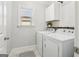 Functional laundry room with modern appliances, white cabinets, tile floors, and natural light at 266 Hanover Dr, Villa Rica, GA 30180