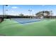 Well-maintained outdoor tennis court with green and blue surface, surrounded by trees and street lamps at 266 Hanover Dr, Villa Rica, GA 30180