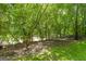 A verdant backyard with a wooded area and a small stream provides a peaceful natural setting at 955 Landmark Dr, Sandy Springs, GA 30342