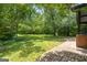 Lush green backyard with mature trees, brick patio, and pathway offer an inviting outdoor space at 955 Landmark Dr, Sandy Springs, GA 30342