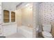 Traditional bathroom featuring vanity storage, wallpaper, and a shower-tub combo with neutral-tone tiling at 955 Landmark Dr, Sandy Springs, GA 30342