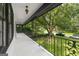 Classic covered porch with ornamental iron railing provides panoramic views of the yard at 955 Landmark Dr, Sandy Springs, GA 30342