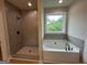 Primary bath features separate shower and soaking tub with window and tile surround at 3019 Beverly Ct, Mcdonough, GA 30252
