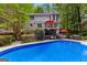 A two-story home overlooks a private backyard with a pool, outdoor bar, and lush landscaping at 103 Everhill, Peachtree City, GA 30269