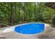 Backyard swimming pool surrounded by concrete decking, lush greenery and mature trees for privacy at 103 Everhill, Peachtree City, GA 30269