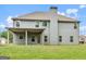 Rear exterior view of the home with a covered porch and large yard at 149 Elkins Blvd, Locust Grove, GA 30248