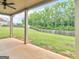 Covered back porch overlooking a spacious backyard with a wood fence and view of the tree line at 149 Elkins Blvd, Locust Grove, GA 30248