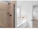 Bathroom showcasing a tile shower and soaking tub by the window at 149 Elkins Blvd, Locust Grove, GA 30248