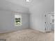 A sunlit bedroom featuring neutral tones and carpet, complemented by a large window with a view at 149 Elkins Blvd, Locust Grove, GA 30248