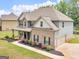 Two-story home with brick accents, well-maintained landscaping, and attached two-car garage at 149 Elkins Blvd, Locust Grove, GA 30248