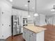 Bright kitchen boasts stainless appliances, granite counters, island, and a seamless open floor plan at 149 Elkins Blvd, Locust Grove, GA 30248