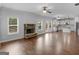 Open-concept living room with a stone fireplace, hardwood floors, and access to a modern kitchen at 149 Elkins Blvd, Locust Grove, GA 30248