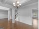 Spacious living room has hardwood floors, wainscoting, and stylish pillars, offering a modern aesthetic at 149 Elkins Blvd, Locust Grove, GA 30248