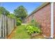 Backyard view featuring a wooden fence, landscaped garden area, and well-maintained lawn at 401 Buckboard Ln, Locust Grove, GA 30248