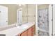 Bathroom features a single vanity, large mirror, and shower with a decorative shower curtain at 401 Buckboard Ln, Locust Grove, GA 30248