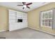 Bedroom with a ceiling fan, window and built-in bookcase with TV at 401 Buckboard Ln, Locust Grove, GA 30248