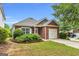 Charming brick home with attached garage, manicured lawn, and mature trees in a quiet neighborhood at 401 Buckboard Ln, Locust Grove, GA 30248