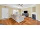Bright living room featuring hardwood floors, a ceiling fan, modern furniture, and a cozy fireplace at 401 Buckboard Ln, Locust Grove, GA 30248