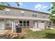 Townhome backyard featuring a grass yard, small patio, partial fence, and brick facade at 3511 Brockenhurst Dr, Buford, GA 30519