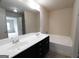 Bathroom featuring a double sink vanity, dark cabinets, and a bathtub with shower at 3511 Brockenhurst Dr, Buford, GA 30519