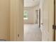 Spacious bedroom featuring neutral carpeting, a window view, and an adjoining doorway at 3511 Brockenhurst Dr, Buford, GA 30519