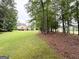 Expansive backyard with a well-maintained lawn, mature trees, and partial view of the home at 99 Oakwind Pt, Acworth, GA 30101