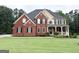 Beautiful two-story brick home with a well-manicured lawn and mature landscaping at 99 Oakwind Pt, Acworth, GA 30101