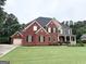 Charming two-story brick home with attached garage, landscaped front yard, and mature trees at 99 Oakwind Pt, Acworth, GA 30101
