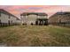 Backyard view of the brick home, featuring a covered patio at 3225 Alhambra Cir, Hampton, GA 30228