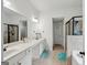 Bright bathroom with dual sinks, a wide mirror, and a separate glass-enclosed shower and bathtub at 3225 Alhambra Cir, Hampton, GA 30228